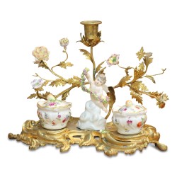 Un encrier \"Putto tenant une guirlande de fleurs\" de style Louis XV en porcelaine.